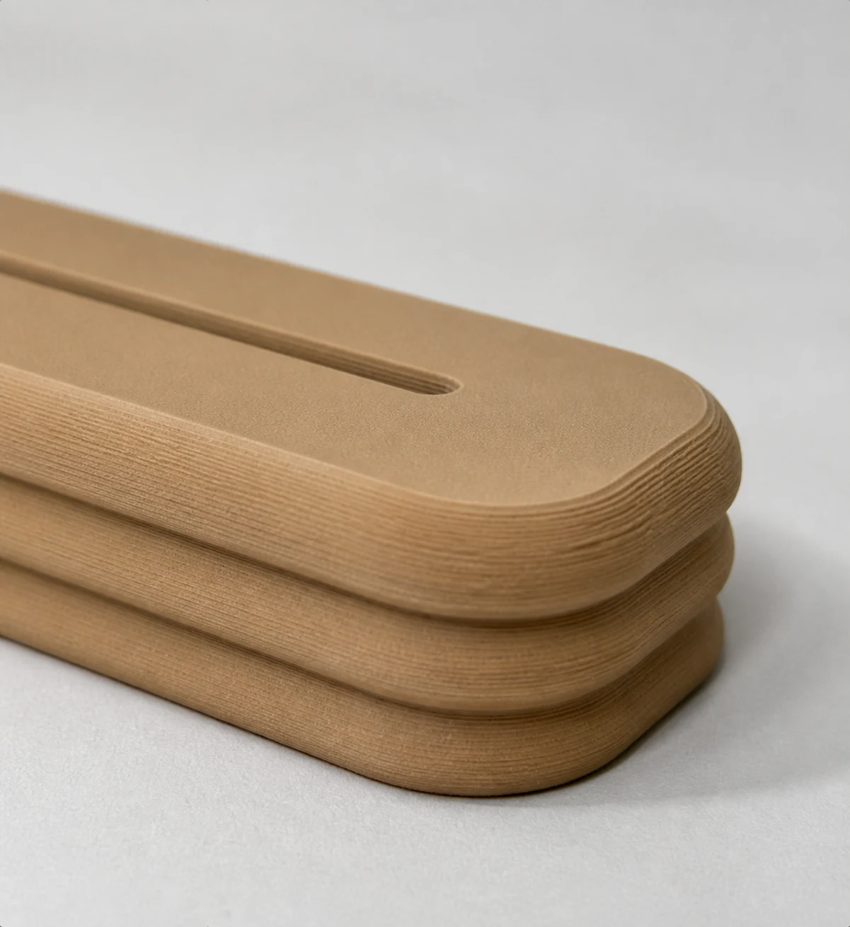 Macro detail of the light wood-tone stand's matte fuzzy-skin texture and three printed contours.